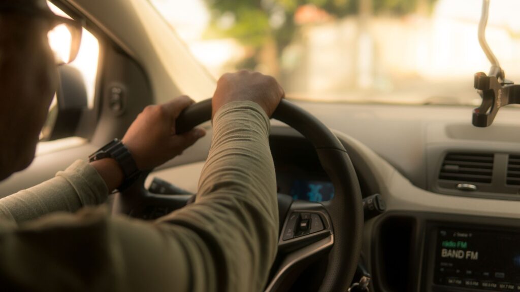 Person driving car, steering wheel close-up