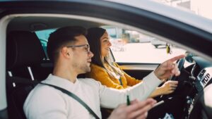 Driving lesson with instructor pointing directions.