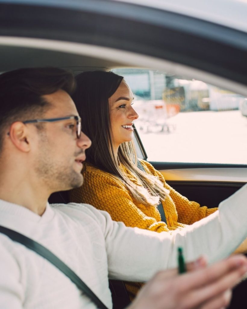 Driving lesson with instructor pointing directions.